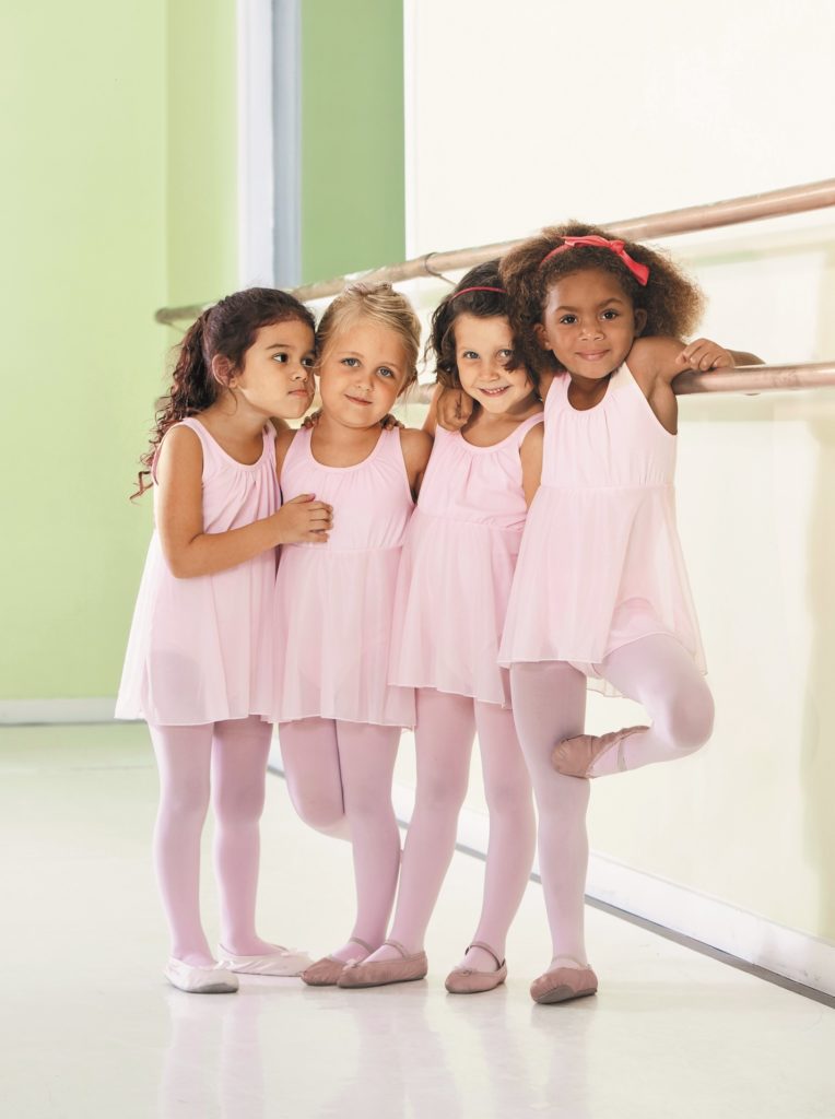 Vier Mädchen im Ballerina Outfit lächeln in die Kamera 